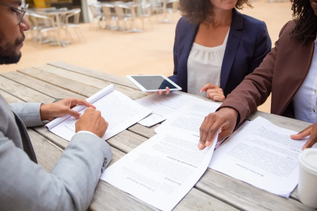 personas firmando un contrato en una mesa